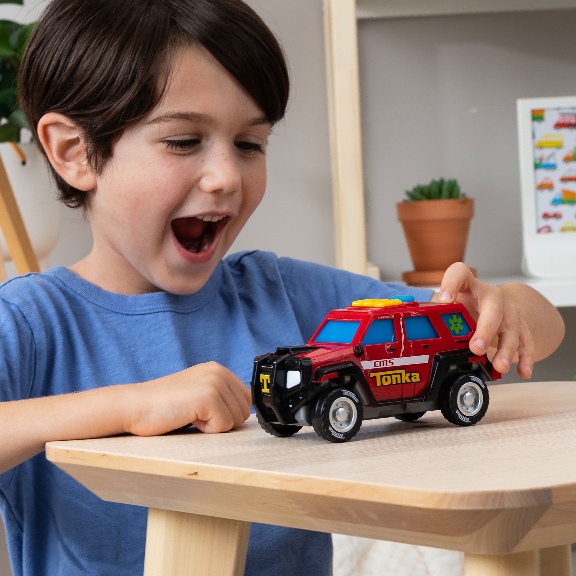 Tonka Mighty Force - First Responder - Lifestyle shot of excited boy paying with vehicle on a table